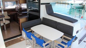 A compact galley with a table and chairs, a small kitchenette, and a view of the marina. - Sun-Kissed Sailing Adventure in Split, Croatia (Split)