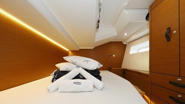 A compact cabin with a bed, pillows, and a wooden wardrobe. - Sun-kissed Sailing Adventure in Split-Dalmatia, Croatia (Trogir)