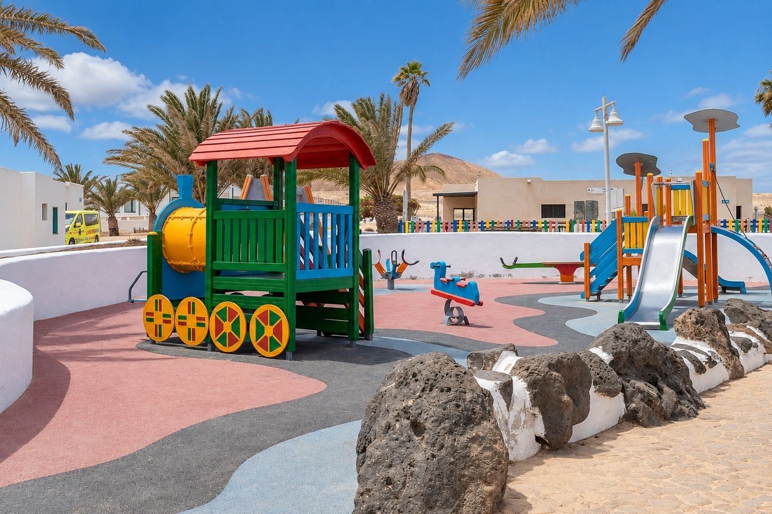 A playground with a train ride, slides, and a wavy path.