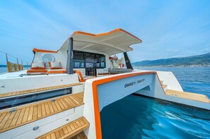 A yacht with a covered deck area, a pool, and a view of the coastline. - Sun-Kissed Sailing Adventure in Split, Croatia (Split)