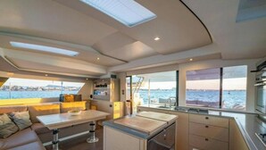 Ein modernes Interieur mit Essbereich, Küche und großen Fenstern mit Blick aufs Wasser.