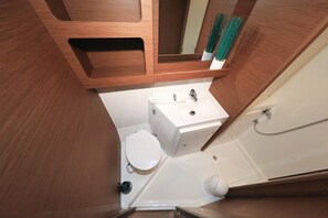 Ein kleines Badezimmer mit Toilette, Waschbecken und Dusche.