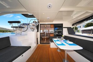 Das Interieur einer Yacht mit Essbereich, Küche und einer Sitzecke mit Meerblick.