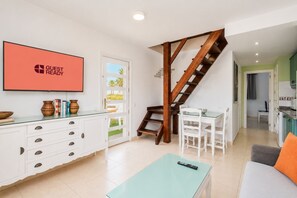 A modern living room with a staircase, a dining area, and a kitchen. - GuestReady - Bright Retreat with Outdoor Pool (Corralejo)
