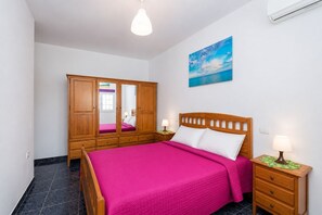 Ein Schlafzimmer mit einem Bett, einem Holzschrank und einem Bild an der Wand.