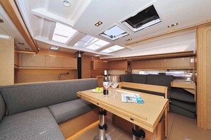 A compact, well-lit interior with a dining area, seating, and a small kitchen. - Sun-Kissed Sailing Adventure in Zadar, Croatia (Biograd na moru)
