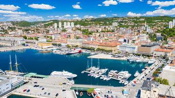 Un port de plaisance avec des bateaux, un quai et des bâtiments en arrière-plan.