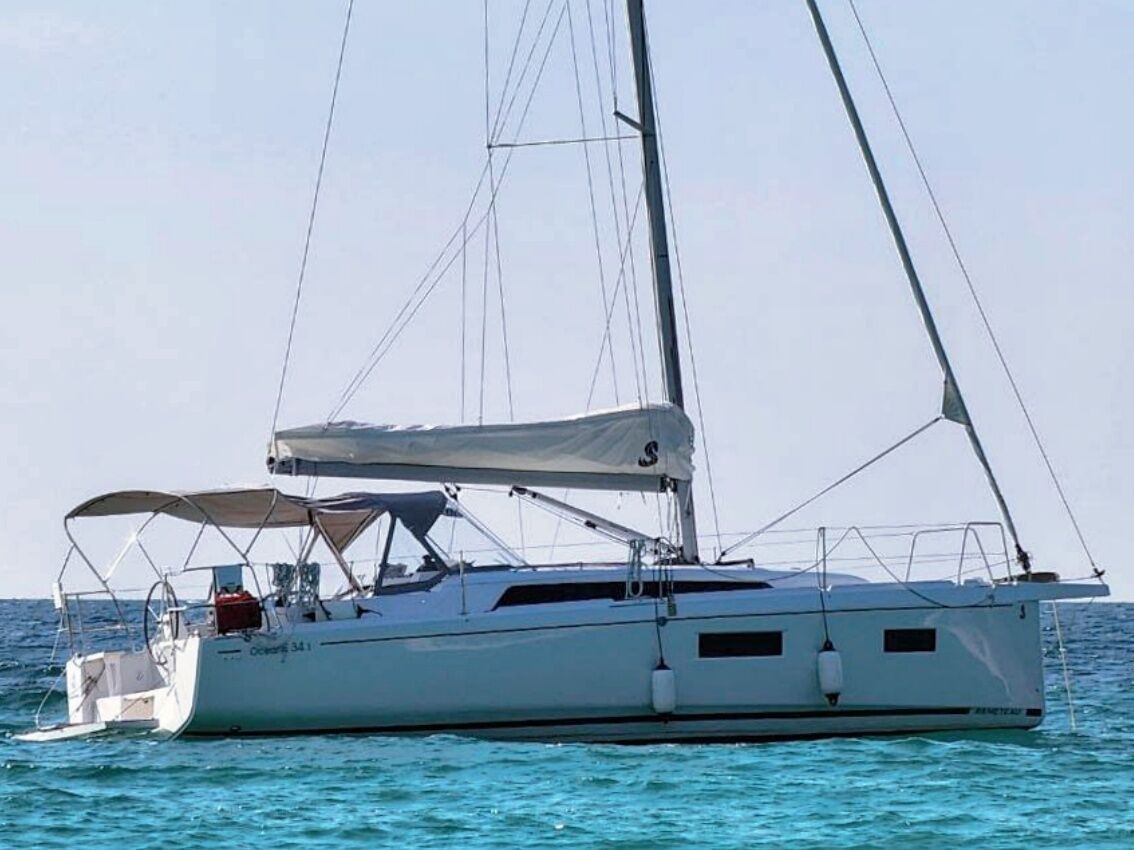 Un velero con cabina, zona cubierta en la cubierta y mástil.