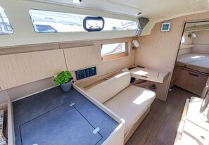 A compact boat interior with a kitchenette, a seating area, and a small window. - Sun-Kissed Sailing Adventure in Split, Croatia (Split)