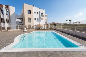 Ein modernes Gebäude mit Swimmingpool, Außenbereich und einem eingezäunten Bereich.