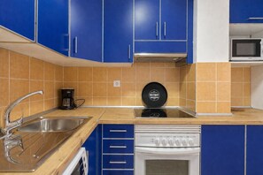 A kitchen with blue cabinets, a microwave, a coffee maker, and a dishwasher. - GuestReady - Rosamar 301 P (Las Palmas de Gran Canaria)