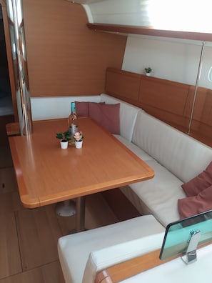 Ett kompakt vardagsrum med ett träbord, bekväma sittplatser och en liten krukväxt.