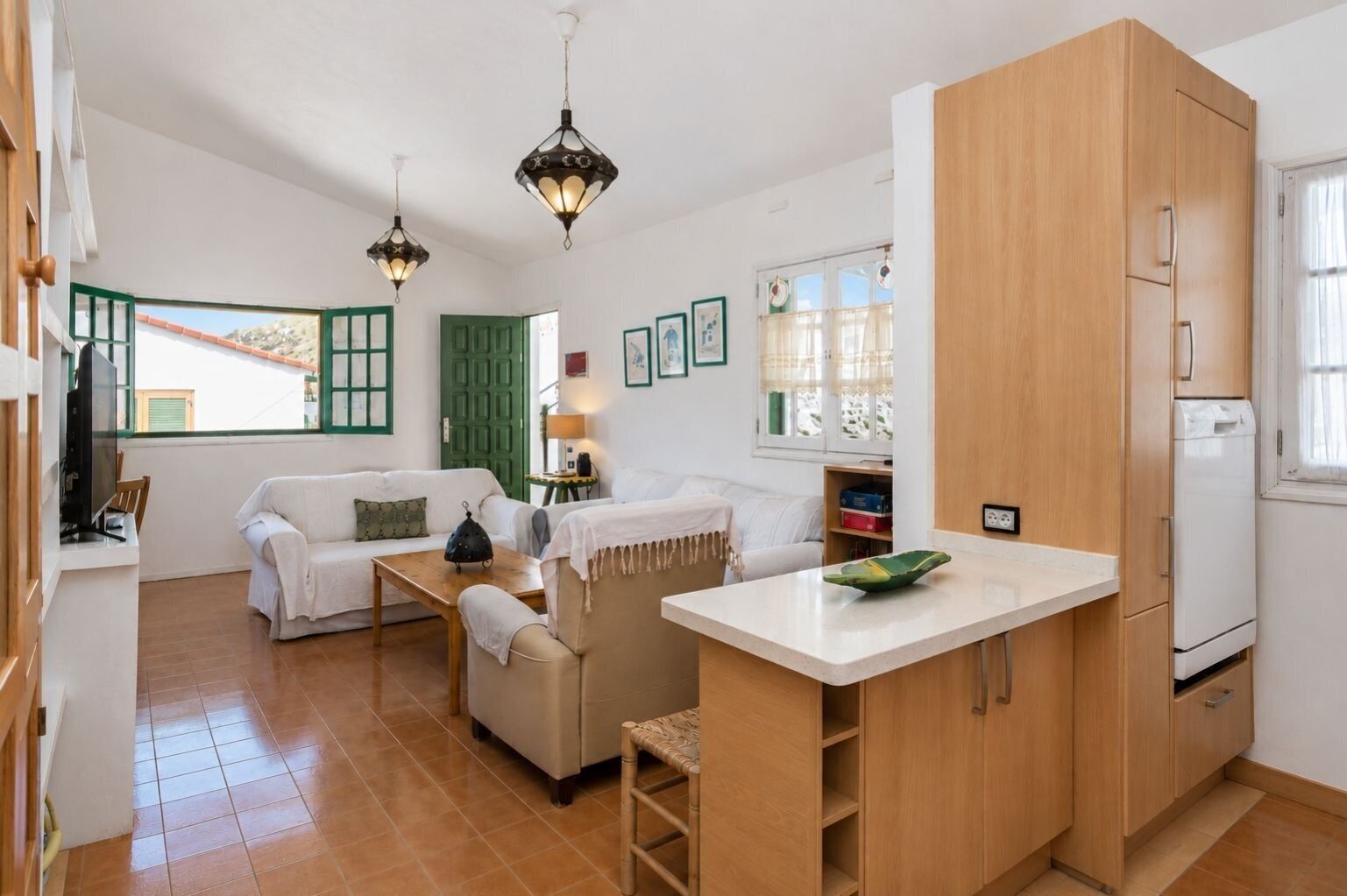 A compact living space with a kitchenette, a dining area, and a sofa set.