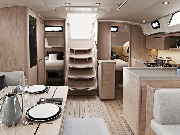 A compact kitchen with a dining area, a built-in stove, and a small refrigerator.