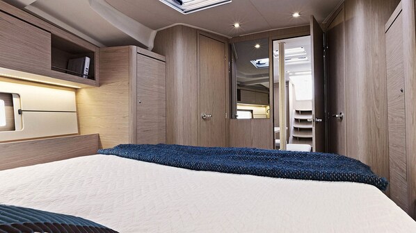 A bedroom with a bed, wardrobe, and built-in shelves.