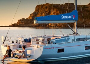 A sailboat with the name 'Sunsail 46' and a person on the deck.