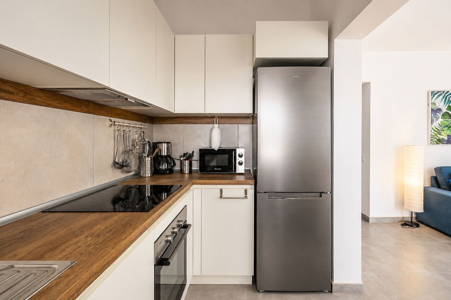 Una cocina moderna con un refrigerador de acero inoxidable, un microondas y una estufa.