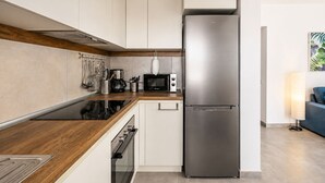 A modern kitchen with a stainless steel refrigerator, a microwave, and a stove. - GuestReady - Melocotones Family Bungalow (San Bartolomé de Tirajana)