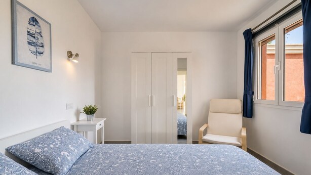 A bedroom with a bed, a chair, a desk, and a wardrobe. - GuestReady - Melocotones Family Bungalow (San Bartolomé de Tirajana)