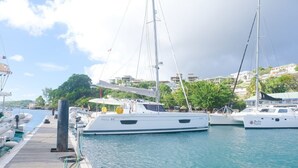 A marina with several boats docked, a wooden pier, and buildings in the background. - Caribbean Bliss: Sun-soaked Sailing Adventure from San Vicente y las Granadinas (Ribishi)