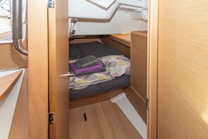A compact, wooden interior with a bed, a small table, and a window. - Sun-Kissed Sailing Adventure in Islas Baleares, Mallorca (Portocolom)