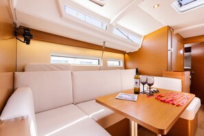 Ein modernes Interieur mit einem Holztisch, weiß gepolsterten Sitzmöglichkeiten und einem Oberlicht.