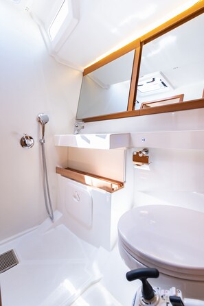 Ein modernes Badezimmer mit Waschbecken, Spiegel und Dusche.