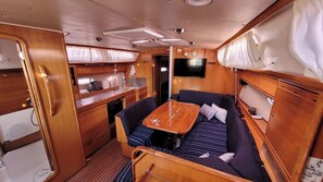 A compact galley with a sink, stove, and storage cabinets. - Sun-Kissed Sailing Adventure in Islas Sarónicas (Alimos)
