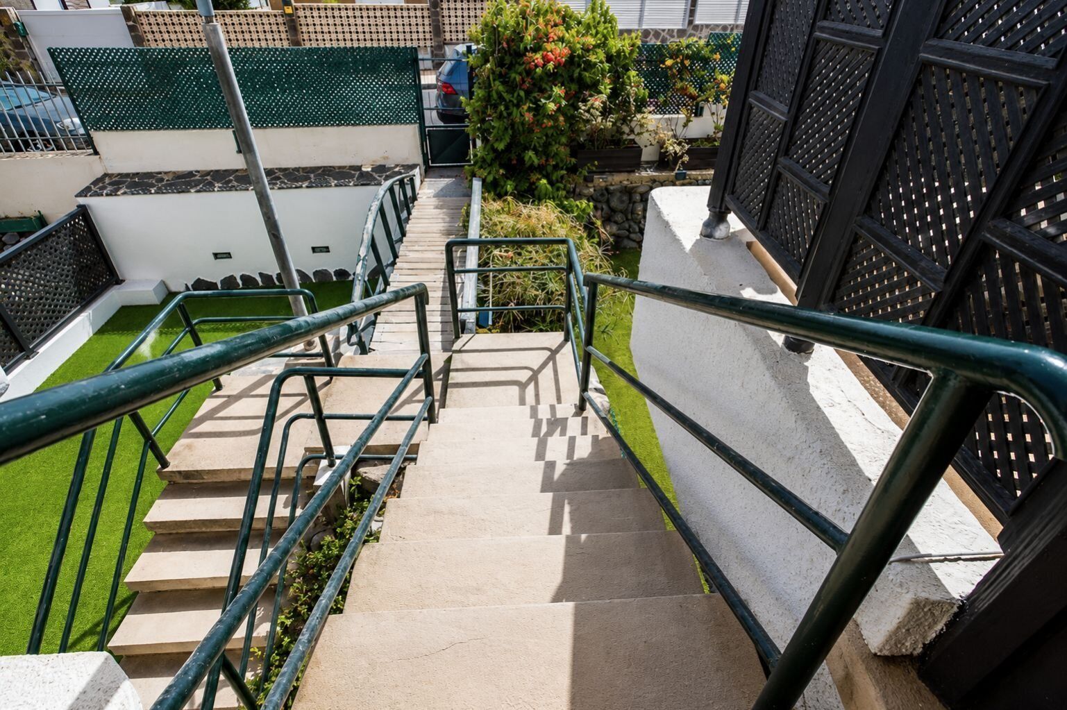 Una escalera exterior con barandillas metálicas que conduce a un área cerrada.