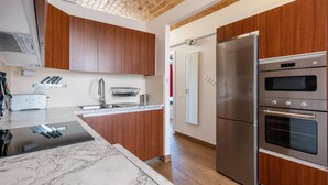 Een moderne keuken met houten kastjes, een roestvrijstalen koelkast en een oven.