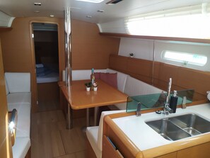 A compact kitchen with a sink, a small countertop, and a window above the sink. - Sibenik Sun and Beach Sailing Extravaganza (Skradin)