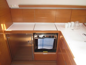 A compact kitchen with a built-in oven, a sink, and a small countertop.