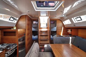 Ein kompaktes Wohnmobil-Interieur mit einer Küchenzeile, einem Essbereich und einer Schlafkoje.