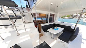 A yacht's interior with a dining area, seating, and a view of the sea. - Sun-kissed Sailing Adventure in Split-Dalmatia, Croatia (Trogir)