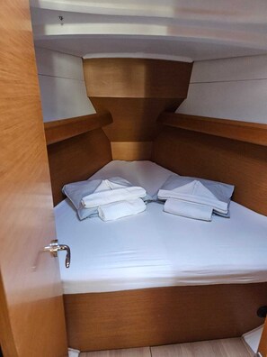 A compact, wooden interior with a small bed and neatly folded towels. - Sibenik Sun and Beach Sailing Extravaganza (Skradin)