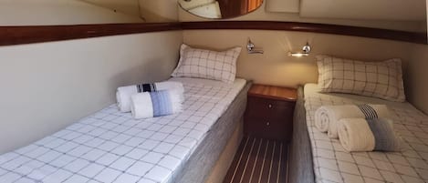 Une cabine compacte comprenant deux lits, une petite table et un miroir.
