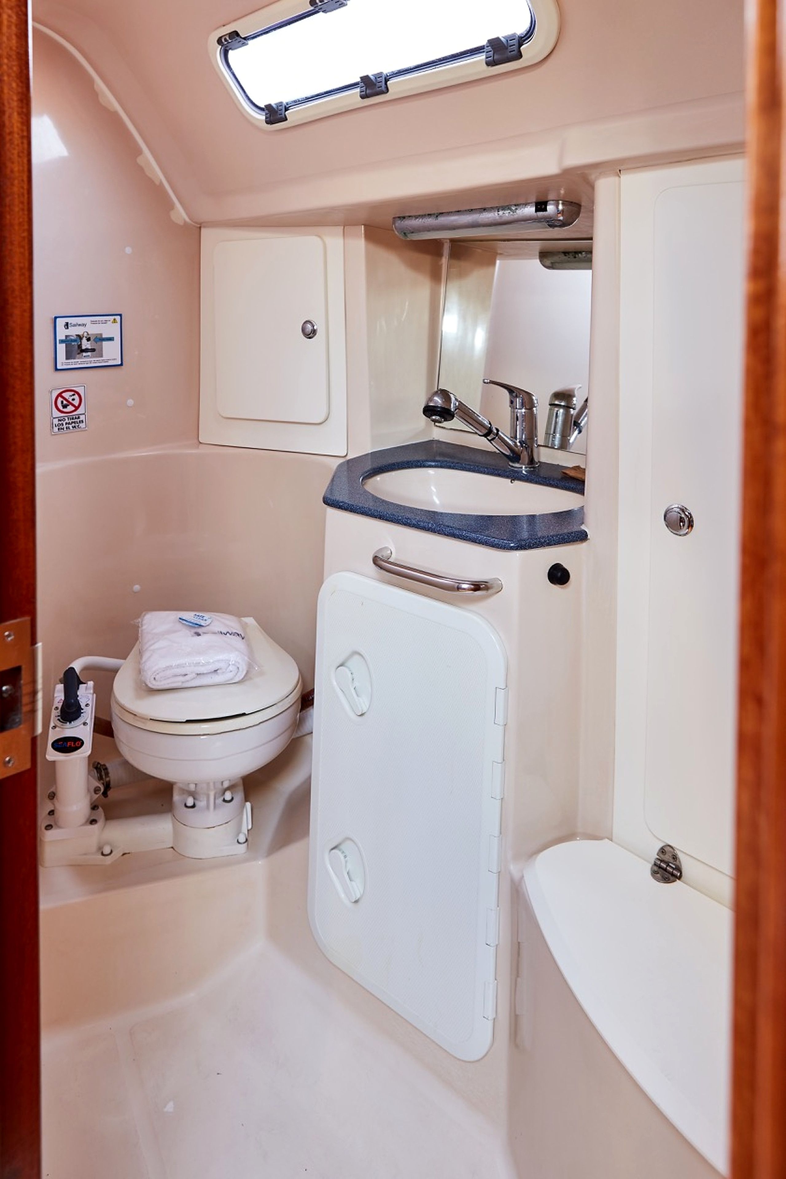 A compact bathroom with a toilet, sink, and shower.