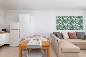 A modern living space with a dining area, a kitchenette, and a sofa. - GuestReady - Las Tabaibas Sea View Retreat (Puerto del Carmen)