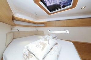 Ein modernes Interieur mit einem Bett, einem Oberlicht und integrierten Stauraum.