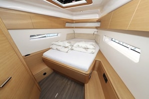 A compact, well-lit interior with a bed, built-in storage, and skylight windows. - Sun-Kissed Sailing Adventure in Zadar, Croatia (Biograd na moru)