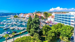 A coastal town with a marina, buildings, and a prominent church. - Sun-Kissed Sailing Adventure in Zadar, Croatia (Biograd na moru)