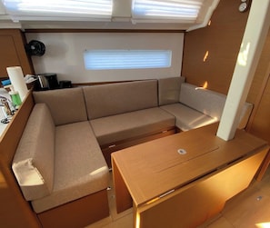A compact living space with a sofa, a table, and a window. - Sibenik Sun and Beach Sailing Extravaganza (Skradin)