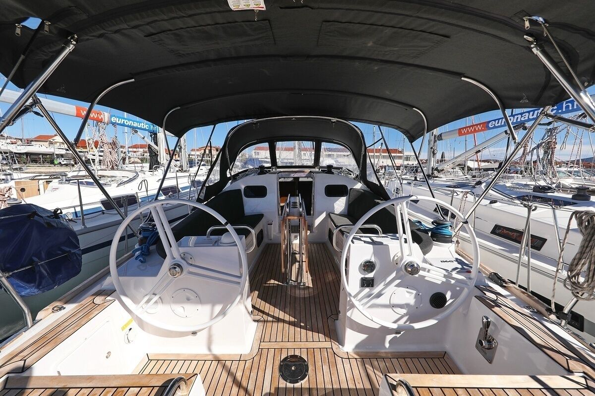 A boat deck with a steering wheel, a central console, and a canopy overhead.