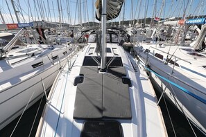 Marina con varios veleros amarrados, destacando un paseo central y aparejos suspendidos.