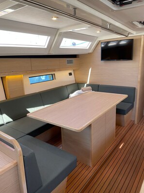 A compact galley with a central island, seating, and a flat-screen TV.