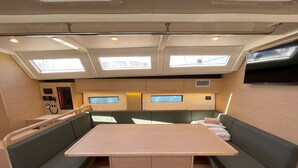 A compact, well-lit interior with a central table, cushioned seating, and skylights. - Sun-Kissed Sailing Adventure in Northern Croatia (Punat)