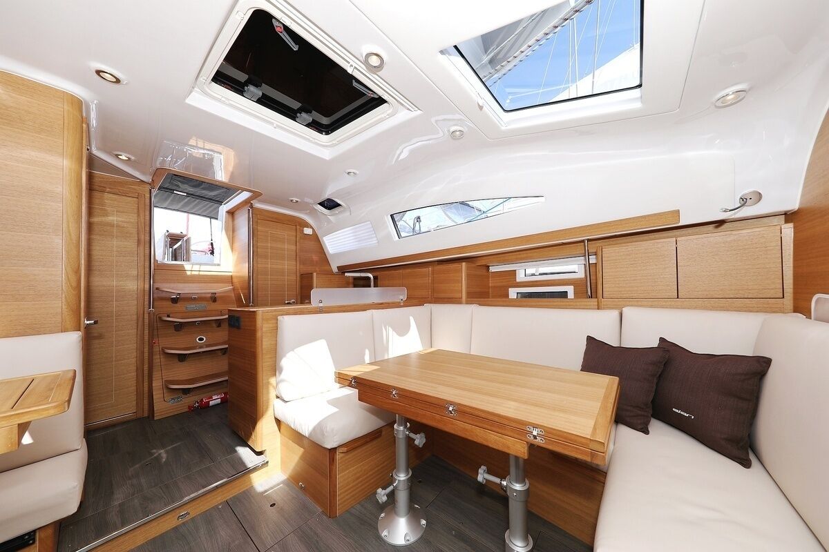 A compact, well-lit interior with a dining area, seating, and storage cabinets.