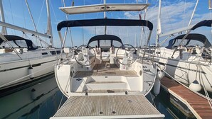 Ein Yachthafen mit mehreren Segelbooten, darunter ein Boot mit überdachter Deck und Steuerrad.
