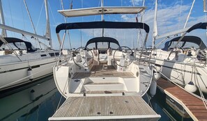 A marina with multiple sailboats docked, featuring a central boat with a covered deck and a steering wheel. - Sun-Kissed Sailing Adventure in Zadar, Croatia (Drage)