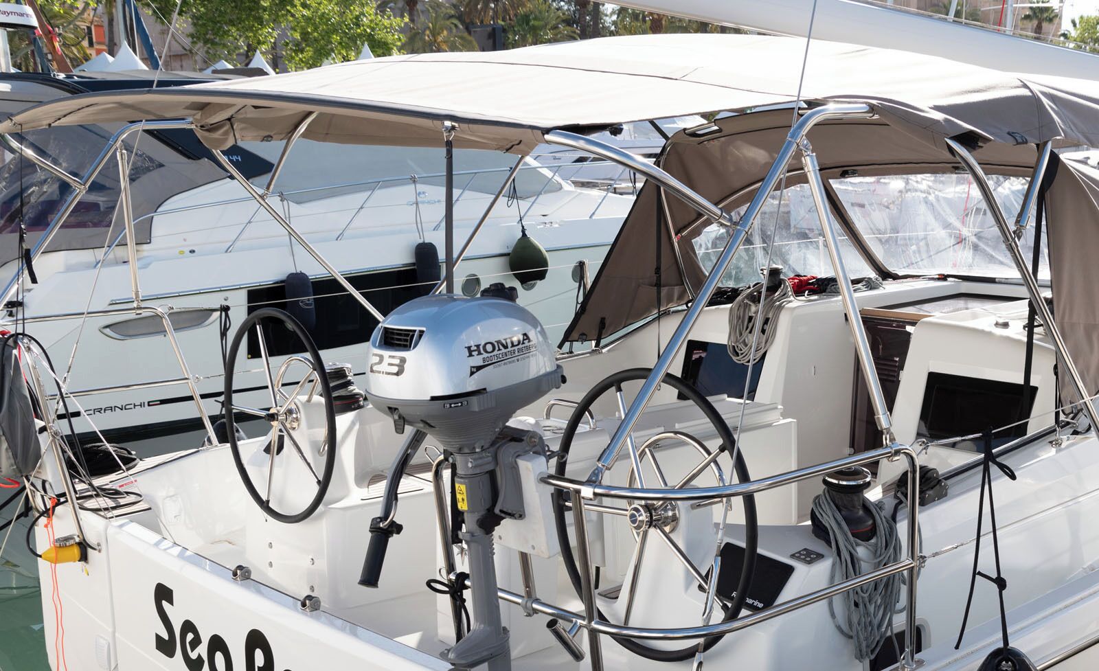A boat with a Honda outboard motor, a steering wheel, and a canopy.